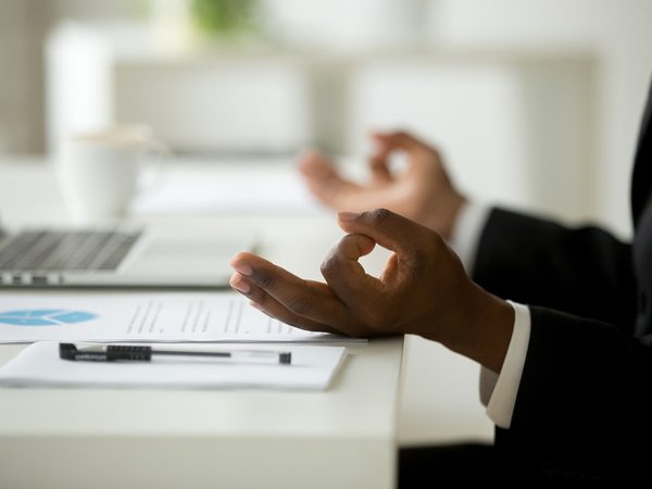 Hände einer Person am Schreibtisch nach dem Arbeitstag