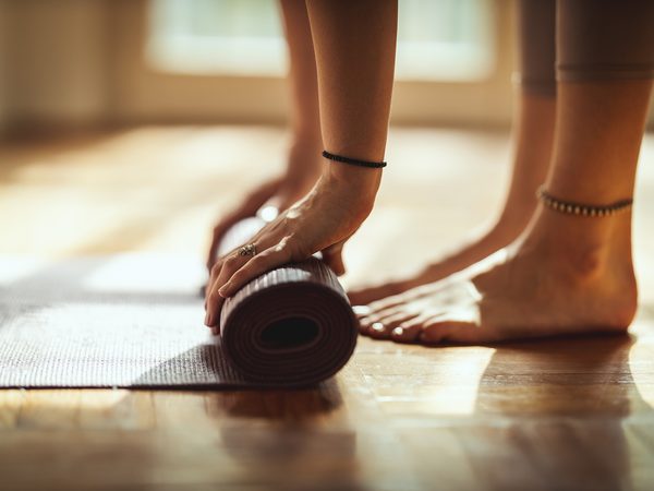 Füße auf der Yogamatte mit Yogablock