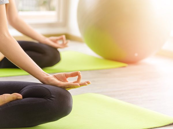 Frau auf der Yogamatte im Sitzen bei Morgenlicht